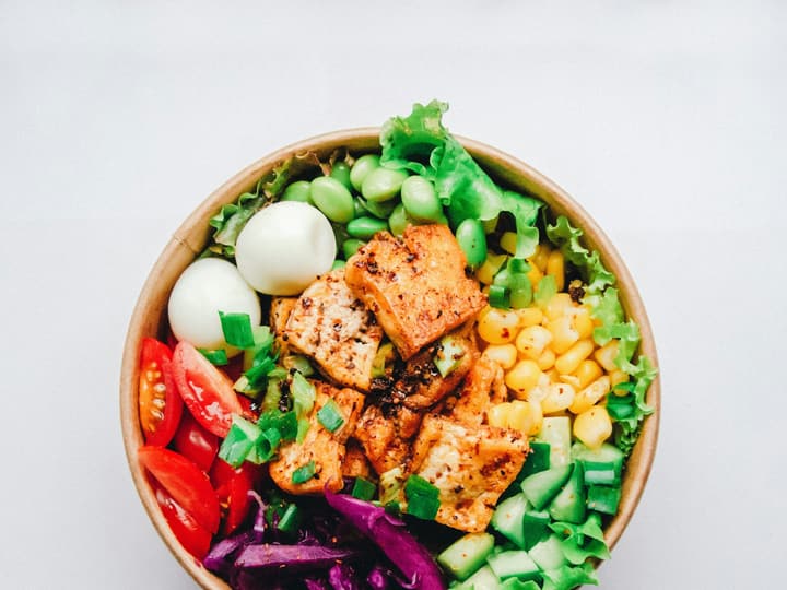 A protein bowl of chicken, egg, sweetcorn and mixed leaves